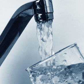 Water flowing from a faucet into a glass.